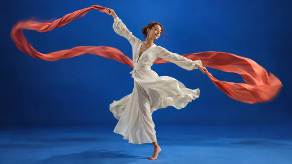An expressive dancer surrounded by flowing fabric